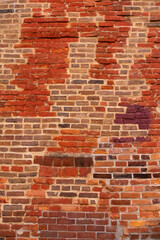 
Vertical view of old wall with patches of different coloured bricks in irregular pattern