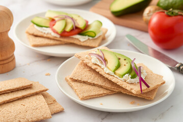 Plates with crispbread with different toppings. Low angle view. Studio shot.