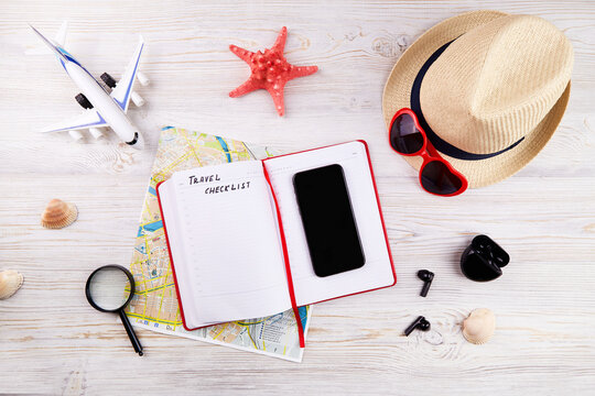 Travel checklist concept. Map, phone, notebook for to do list and other travel accessories. Planning summer vacation. Top view.