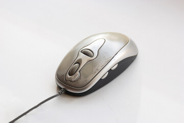 An image of a worn and well-used computer mouse, bearing the marks of prolonged usage