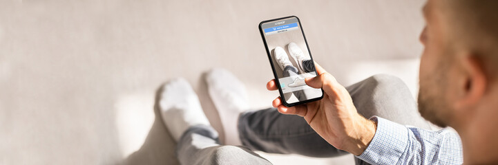 Fototapeta na wymiar Man Trying Virtual Sneakers In Online Shop