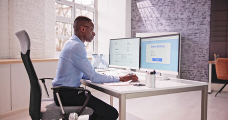 Young Businessman Looking At Invoice While Doing Online Banking