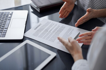 Business people discussing contract signing deal while sitting at the glass table in office, closeup. Partners or lawyers working together at meeting. Teamwork, partnership, success concept