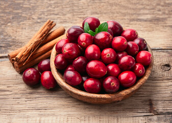 Sweet cranberries with cinnamon pods on wooden tables
