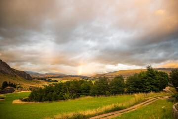 rainbow in a sunset over the hills of the valle simpson coyhaique, aysen region, patagonia, chile