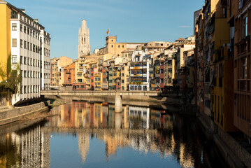 Fototapeta na wymiar The colorful houses lining the riverbanks of Girona in Catalunya, Spain, add a picturesque charm to the city