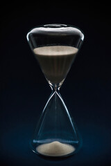Closeup of a hourglass with sand on black background