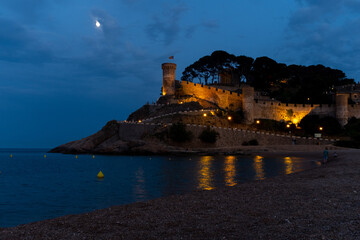Fototapeta na wymiar The medieval castle in Tossa de Mar, Spain, offers a breathtaking view of the beach and sea at night