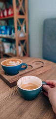 Two cups of cappuccino on the table in a coffee shop on a wooden table