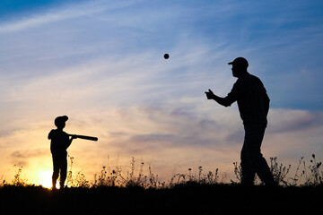 A Happy child with parent playing baseball concept in park in nature