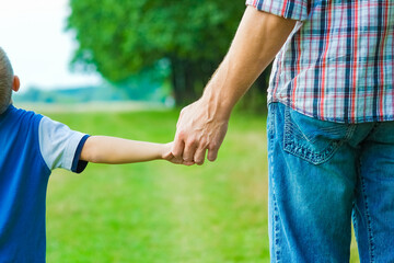 beautiful hands of parent and child outdoors in the park