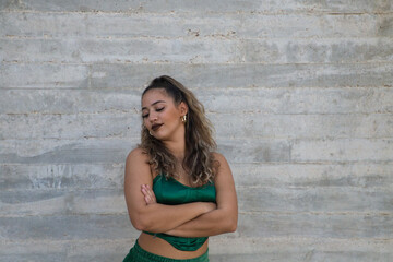 Portrait of Latin woman, young and beautiful dancing modern dance on a gray cement background on the street making different expressions and postures. Concept dance, art, action, beauty, youth art.
