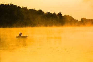 fisherman on the river in the fog in the park on the nature