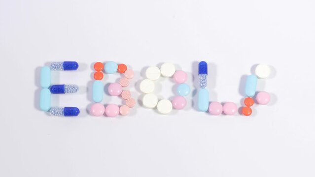 Colored medical drugs pills, tablets and capsules make word ebola on white background. Concept of medical treatment, virus protection, cure. Stop motion animation.