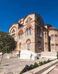 Fototapeta premium Hagia Triada neo-byzantine Cathedral facade exterior in Piraeus, Holy Trinity Greek Orthodox church, Piraeus city street view, Attica, Greece, summer sunny day with a blue sky