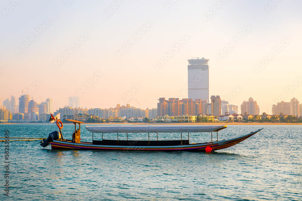 Sticker Dubai, UAE. Tourists boat at Palm Jumeirah  at sunset