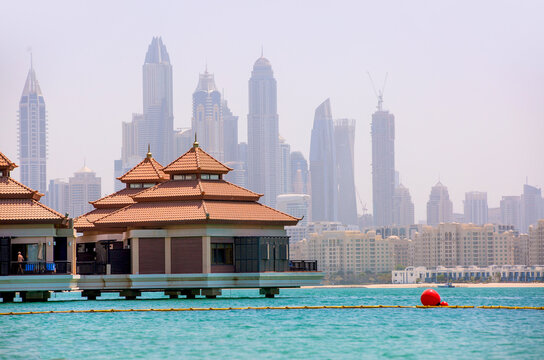 Dubai, UAE.. Villas at Palm Jumeirah and Dubai Marina skyscrapers at background 