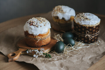 Traditional ukrainian easter cake with white swiss meringue on table. Homemade cruffin cake  Spring cherry blossom and colorful painted eggs. Homemade food.