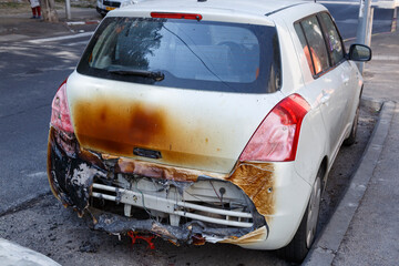 A burnt out car in the early morning mist. The morning after a traffic accident. Setting fire to...