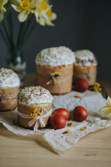 Traditional ukrainian easter cakes with white swiss meringue. Spring daffodil and colorful painted eggs. Homemade food on the table