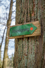 German green Rundgang Tour walk Circuit Sign hanging on a tree trunk at Englischer Garten Eulbach, vertical shot