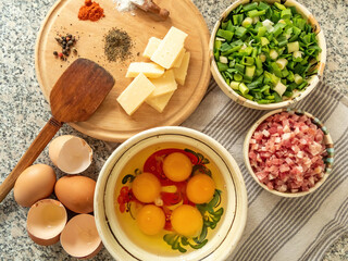 ingredients for preparing omelet with bacon cheese and fresh vegetables