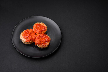 Delicious fresh cutlets or meatballs with spices, herbs and tomato sauce