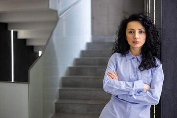 Portrait of serious female boss inside business company office, businesswoman crossed arms looking...