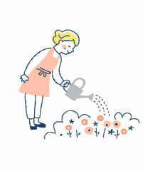 Obraz premium 庭の植物に水を与えているシニア女性