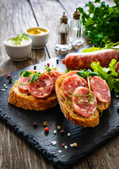 Sliced traditional Polish sausage kielbasa on bread with leafy greens
