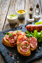 Sliced traditional Polish sausage kielbasa on bread with leafy greens
