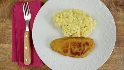 poisson pané et risotto au safran, en gros plan, dans une assiette