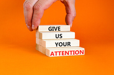 Give us your attention symbol. Concept words Give us your attention on wooden block. Beautiful orange table orange background. Motivational business give us your attention concept. Copy space.