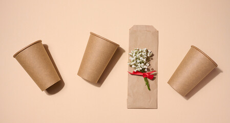 Empty brown paper disposable cups on a beige background, concept eco-friendly, zero waste