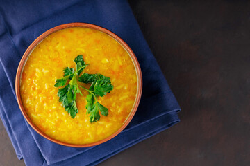 Red lentil soup on a dark brown background. Traditional lebanese or arabic lentil and vegetable...