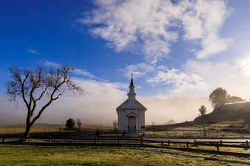 Low fog behind small rural church in Marin County, California at sunrise - 582561696