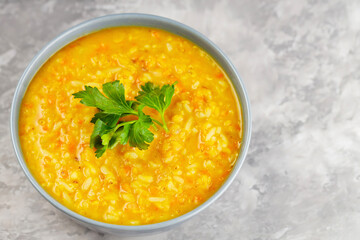 Bowl of lentil soup on concrete. Red lentil soup with fresh parsley. Traditional turkish or arabic dish. Copy space. Top view