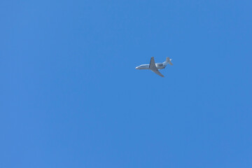 A private jet plane flying in a blue sky between clouds. Transportation. Air travel. Luxury.