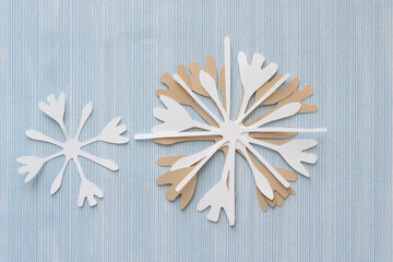floral snowflake paper cutout on blue scrapbook paper with pattern