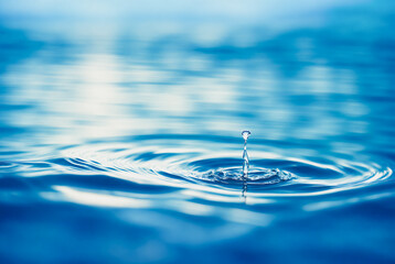 refreshing water drop or splash on the surface with reflection of sun light
