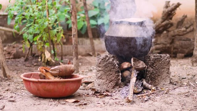 Kettle is heated on a fire with smoke