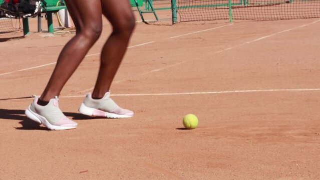 African american woman hold yellow green ball, playing tennis match on clay court surface on weekend free time sunny day. Female player ready to serve. Professional sport concept
