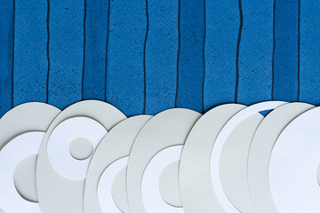 gray paper ovals with rings on blue scrapbook paper with stripes