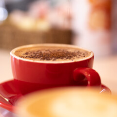 Cappuccino with chocolate in red cup