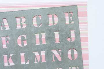 galvanized sheet metal stencil with letters on striped scrapbook paper
