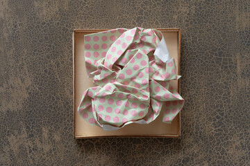 crumpled paper with dots in a shallow wooden box on decorative scrapbook paper