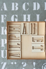 alphabet in a wood box on a metal stencil background