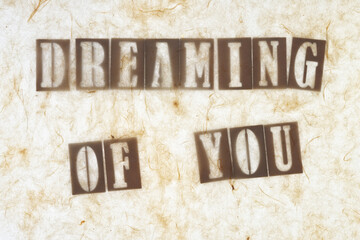 abstract sign with tissue paper on top of wood letters and the message: "dreaming of you"