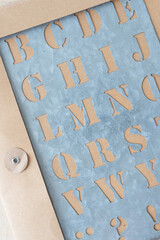 galvanized sheet metal stencil with letters on a cardboard envelope