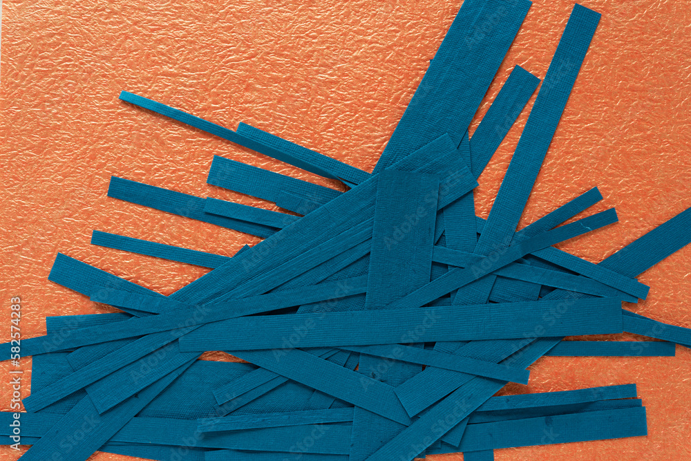 Wall mural cut thin blue paper stripes on textured orange paper